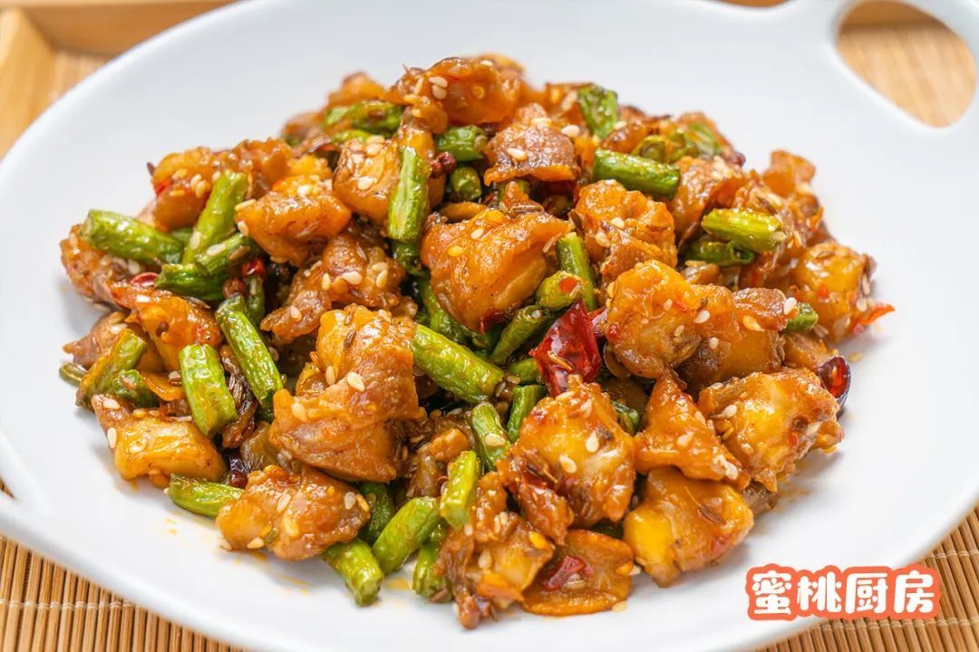 往锅中倒入炸过的鸡脆骨和豆角翻炒均匀,再加入料酒,生抽,白糖和盐翻